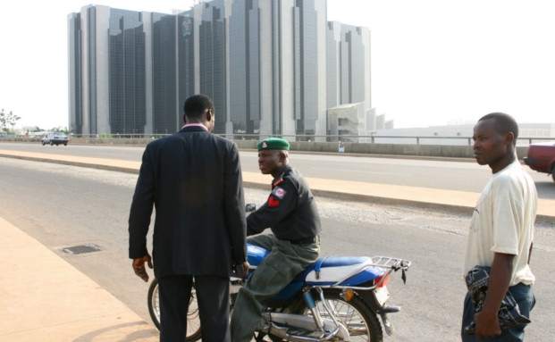 Ein Polizist patrouilliert nahe der nigerianischen Zentralbank in der Hauptstadt Abuja: Nigeria gilt als einer der interessantesten Aktienmärkte Afrikas. Zahlreiche Titel gehören zu den günstigsten der Welt - zumindest nach fundamentalen Kennzahlen. | © BlOOMBERG