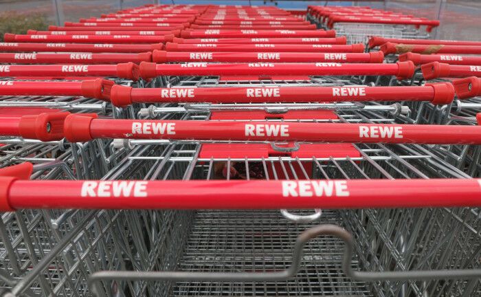 Einkaufswagen der Einzelhandelskette Rewe stehen dicht an dicht: Der Vermögensverwalter der Munich Re will Fachmarktzentren mit Mietern wie Rewe kaufen.  | © imago images  Martin Wagner