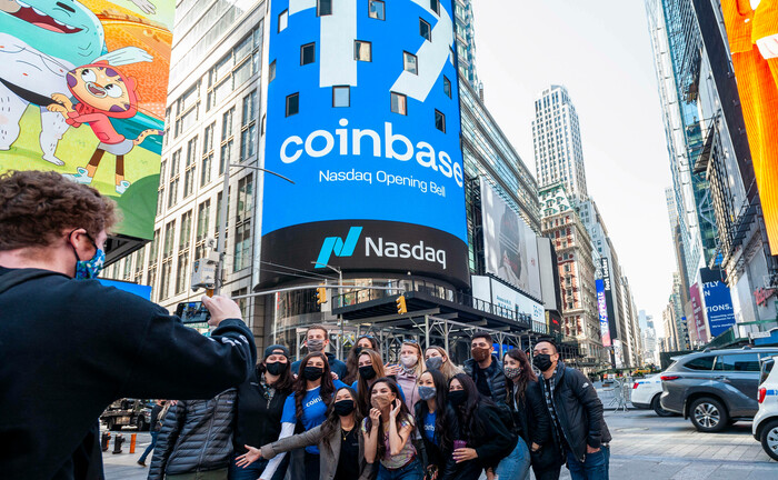 Touristen am Times Square in New York vor einer Werbung der Krypto-Handelsplattform Coinbase