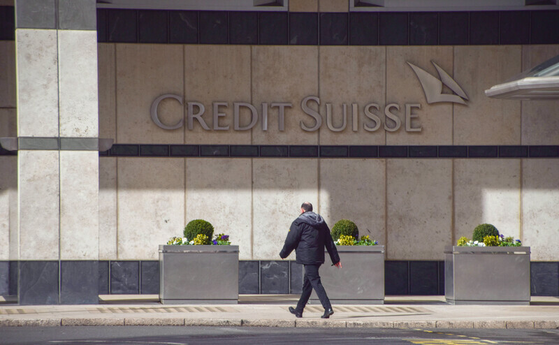 Ein Mitarbeiter läuft am Londoner Sitz der Credit Suisse vorbei: Nach der Übernahme durch die UBS könnten tausende Stellen wegfallen. | © IMAGO / ZUMA Wire