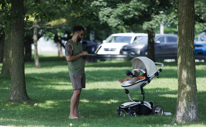 Ein Passant mit Laptop im Grünen: Auch bei digitalen Vermögensverwaltern und Robos ist Greenwashing ein Thema.