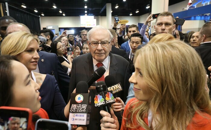 Warren Buffet umringt von Reporterinnen